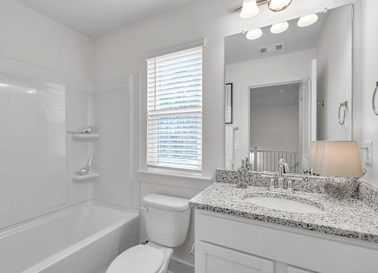 A white bathroom with a sink, toilet, and bathtub.