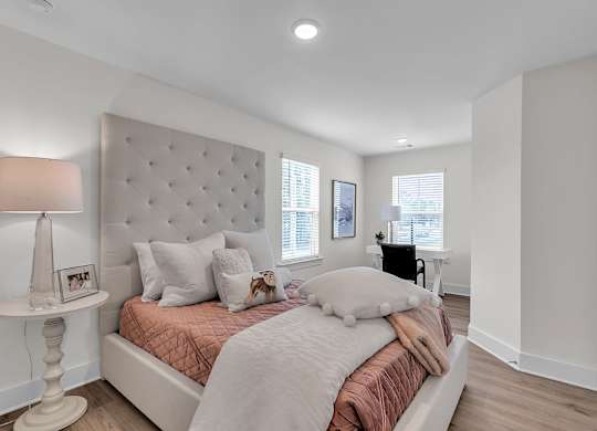 A bedroom with a large bed and a white lamp.