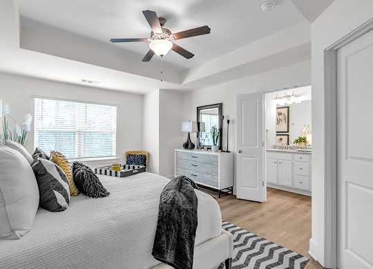 A bedroom with a bed, dresser, and mirror.