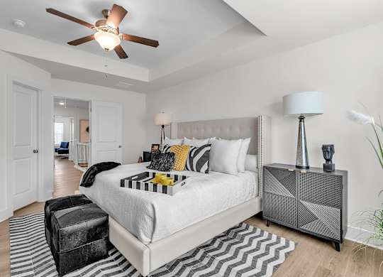 A bedroom with a large bed and a ceiling fan.