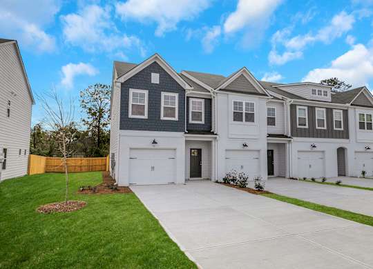 A row of houses with garages and driveways.