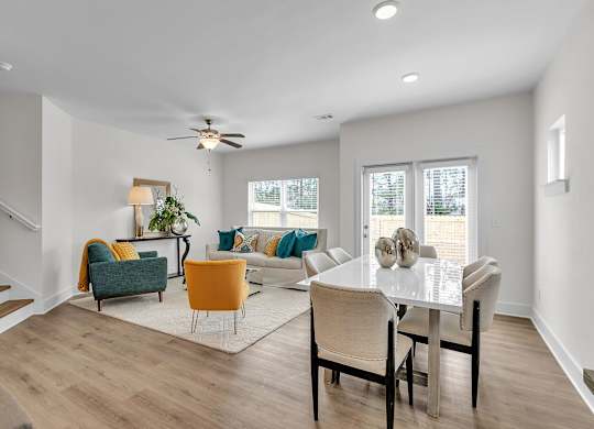 A living room with a white dining table and chairs.