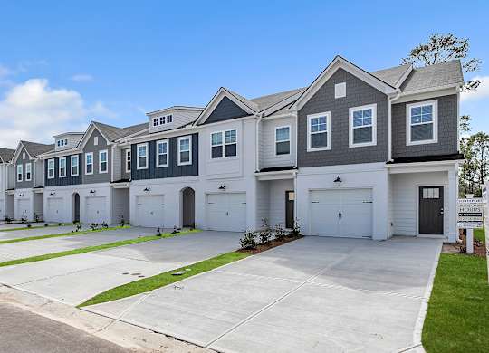 A row of houses with garages and driveways.