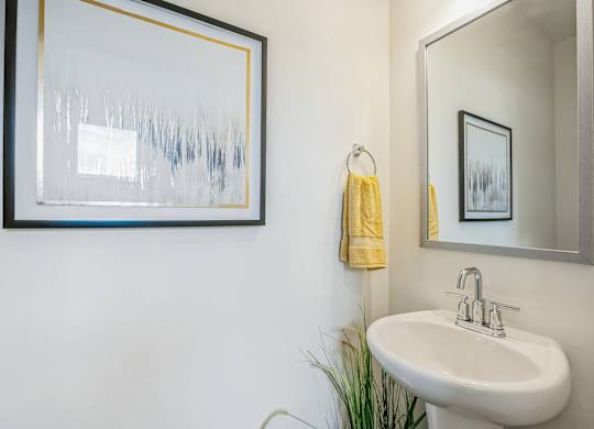A bathroom with a white sink and a yellow towel.