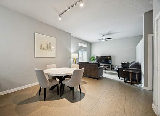 A modern dining room with a white table and chairs.