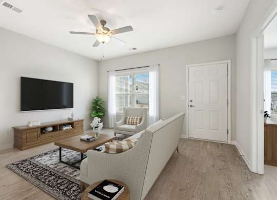 A living room with a couch, a television, and a ceiling fan.