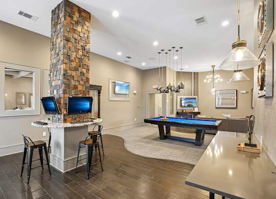 A room with a pool table and a television.