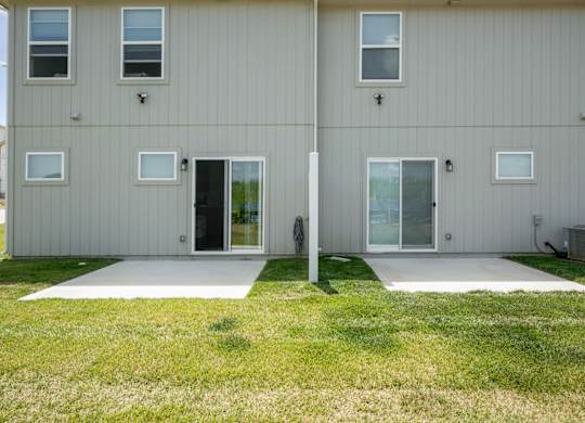 A two-story house with a grey exterior and white trim.