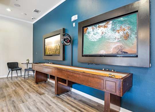 A room with a blue wall and a wooden desk with a chair.