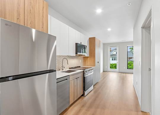 A modern kitchen with wooden cabinets and stainless steel appliances.