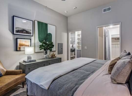 A bedroom with a large bed and a mirror on the wall.