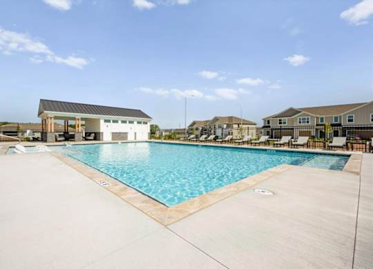 A large swimming pool with a building in the background.