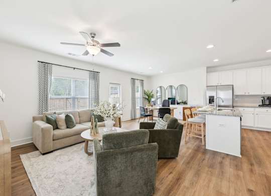 A living room with a couch, chairs, and a dining table.