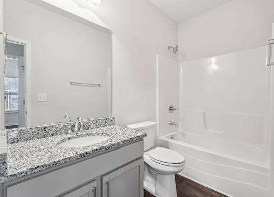 A white bathroom with a sink, toilet, and bathtub.