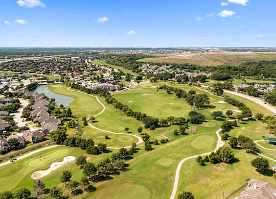 A golf course surrounded by houses.