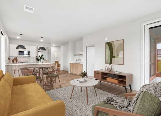 A living room with a yellow sofa and a grey rug.