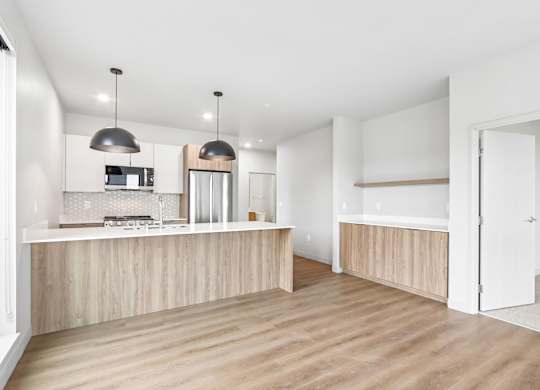 A kitchen with a white countertop and wooden flooring.