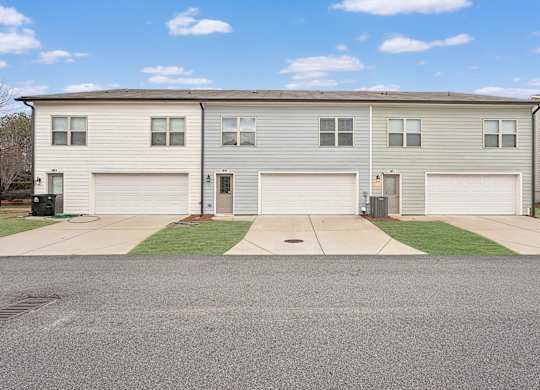A row of houses with garages and driveways.