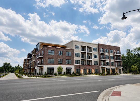 A large apartment building with a red brick facade and white trim.