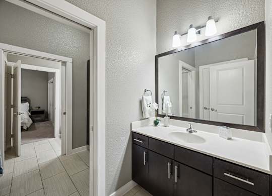 A bathroom with a white sink and a mirror above it.