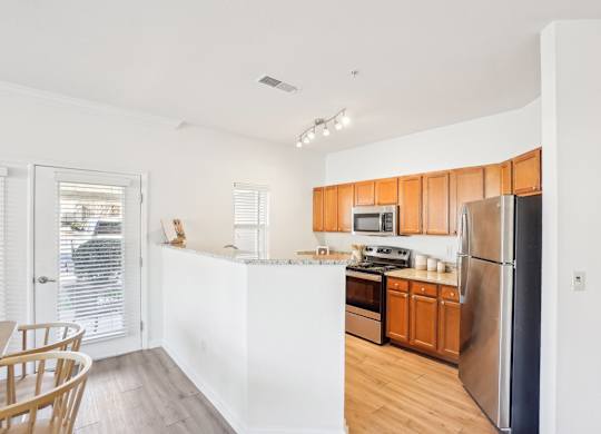 A kitchen with wooden cabinets and stainless steel appliances.