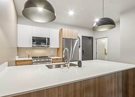 A modern kitchen with a white countertop and wooden cabinets.