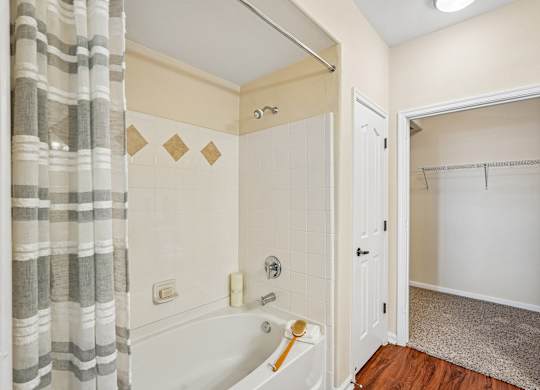 A bathroom with a white tub and a shower curtain.