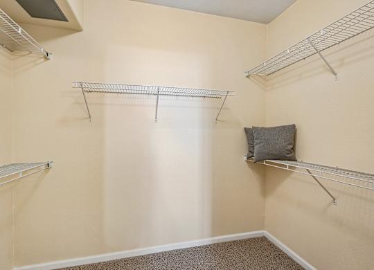 Empty room with three shelves and a pillow on one of them.