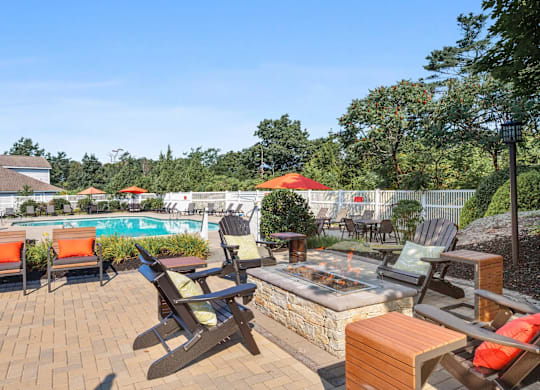 A backyard with a fire pit and chairs.