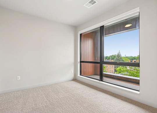 A room with a large window and a view of a cityscape.