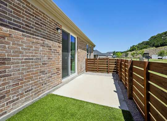 A modern house with a brick wall and a wooden fence.