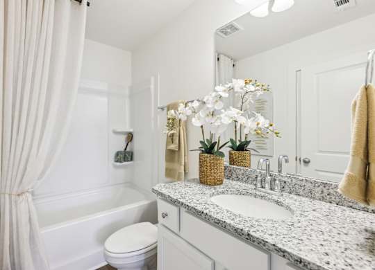 A white bathroom with a toilet, sink, and bathtub.