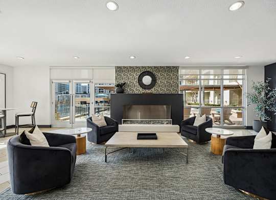 A modern living room with a fireplace and black furniture.