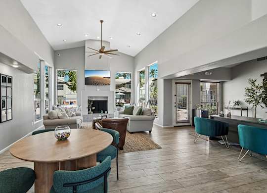 A modern living room with a wooden table and blue chairs.