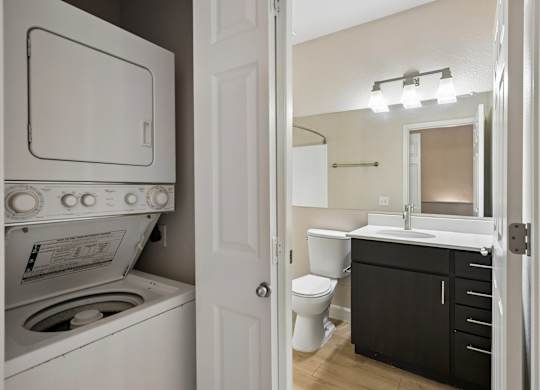 A white oven and washer in a small bathroom.