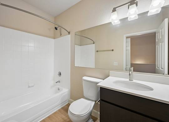 A white bathroom with a toilet, sink, and bathtub.