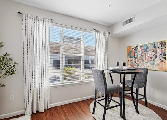 A dining room with a table and chairs.