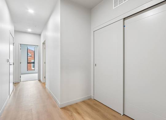 A long hallway with a white door on the right.