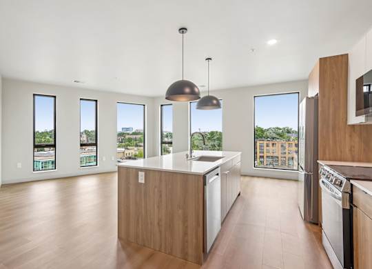 A modern kitchen with wooden cabinets and a large island.