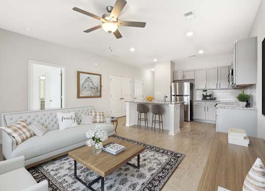 A modern living room with a white sofa and a coffee table in the center.
