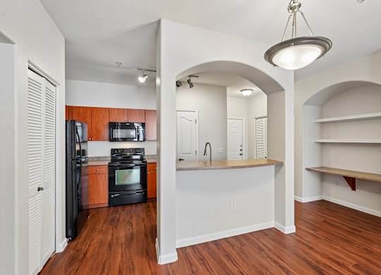 A kitchen with a refrigerator, microwave, and oven.