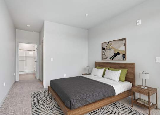 A bedroom with a large bed and a painting on the wall.