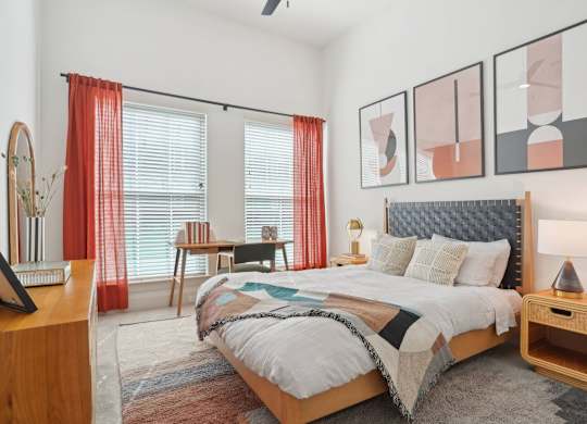 A bedroom with a large bed and a wooden nightstand.