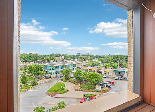 A view from a window looking out at a parking lot and buildings.