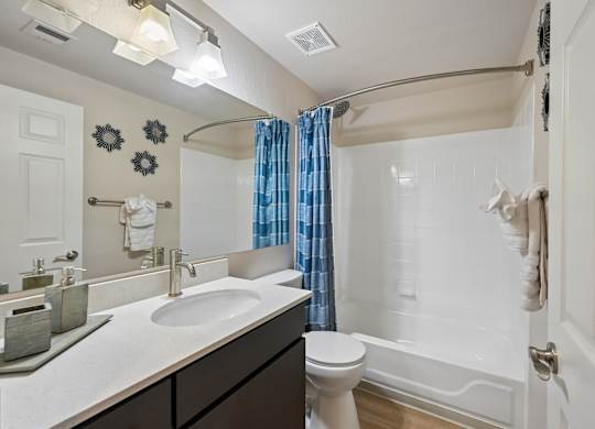 A bathroom with a toilet, sink, and shower.