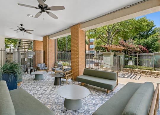 A patio with a table and chairs and a ceiling fan.