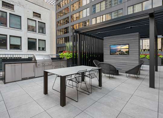 A patio with a table and chairs and a television on a stand.