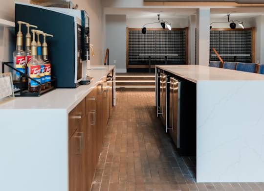 A modern kitchen with a white countertop and wooden cabinets.