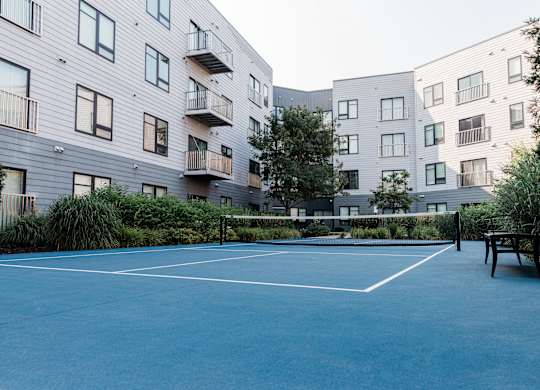 A tennis court is located in front of a building.