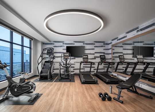 a gym with treadmills and other exercise equipment and a large window